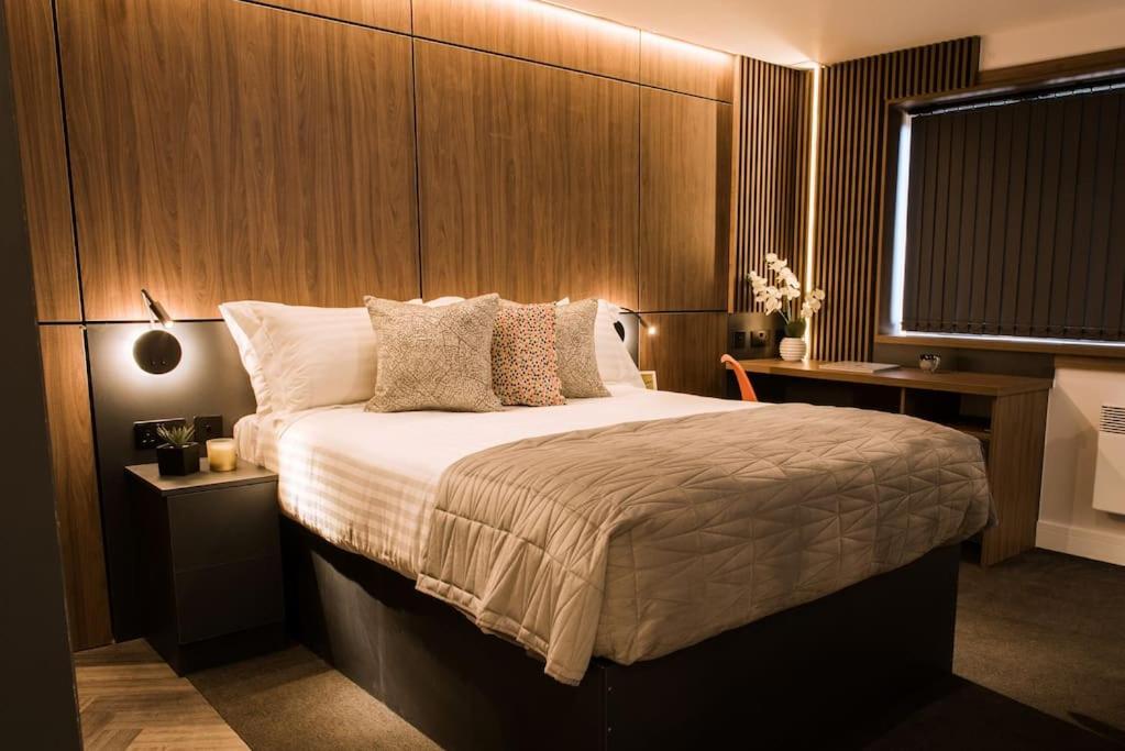 una camera con un grande letto con testiera in legno di Superior 1 Bed Studio 1D near Royal Infirmary & DMU a Leicester