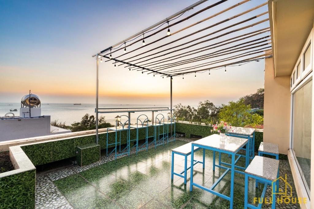 eine Terrasse mit einem Tisch, Stühlen und Meerblick in der Unterkunft Sunset Sea Bãi Dâu Hotel Vũng Tàu in Vũng Tàu