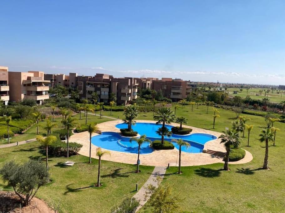 an aerial view of a park with a pool and palm trees at Prestigia Jade Marrakech in Marrakech