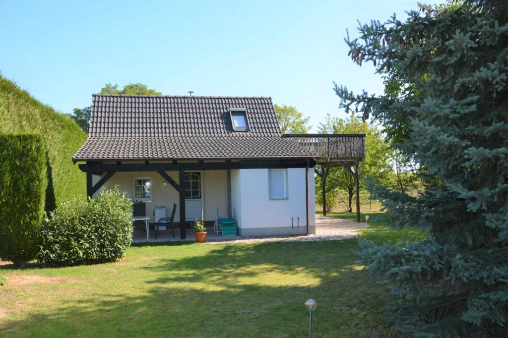una piccola casa bianca con tetto di metallo di Ruhiges, sehr schönes Haus/Grundstück in Elbnähe. ad Arzberg