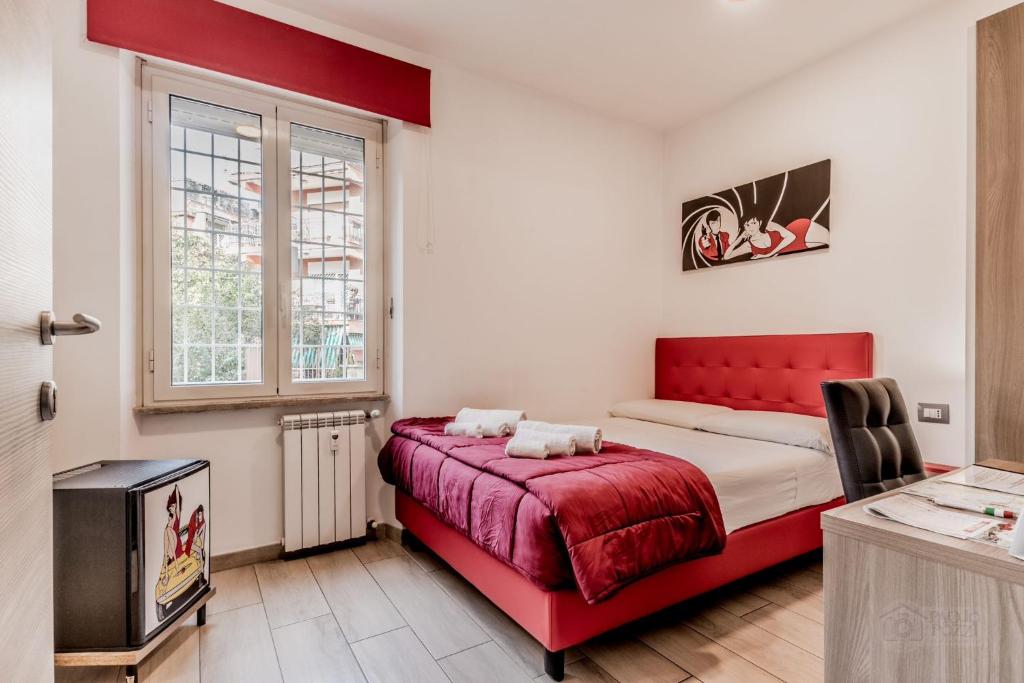 een slaapkamer met een rood bed en een televisie bij Casa Casu in Rome