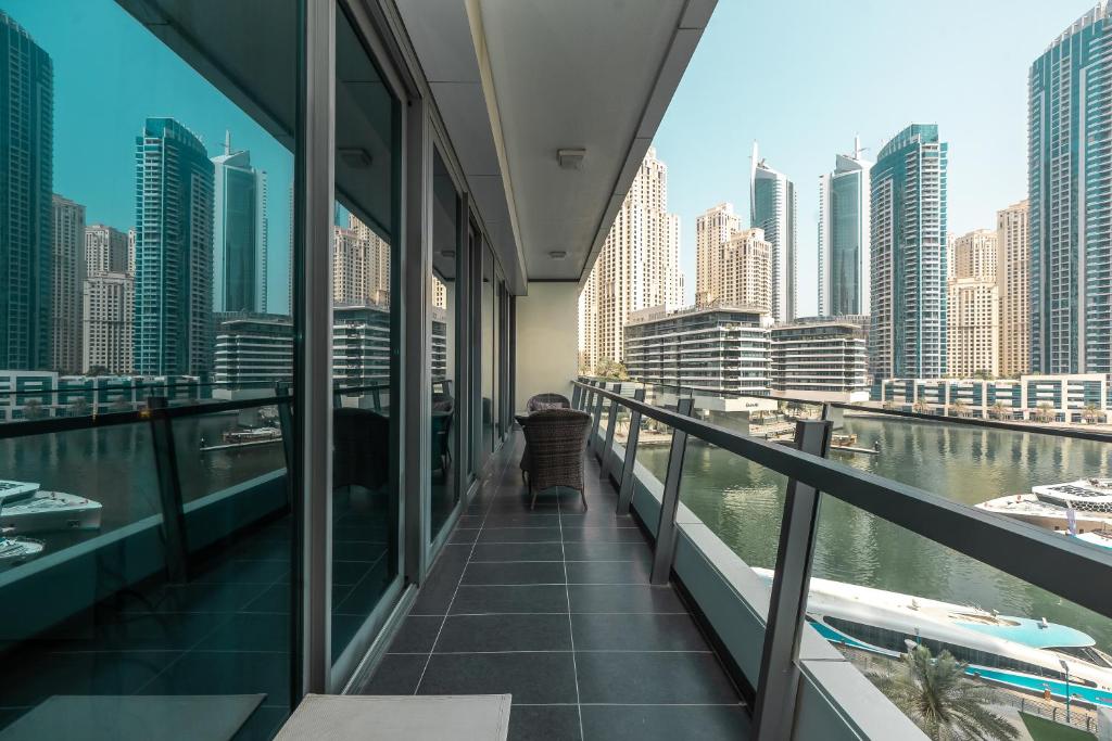 einen Balkon mit Blick auf den Fluss und die Gebäude in der Unterkunft Luton Vacation Homes -Silverene Tower Full marina view ,Dubai Marina A50AB7 in Dubai