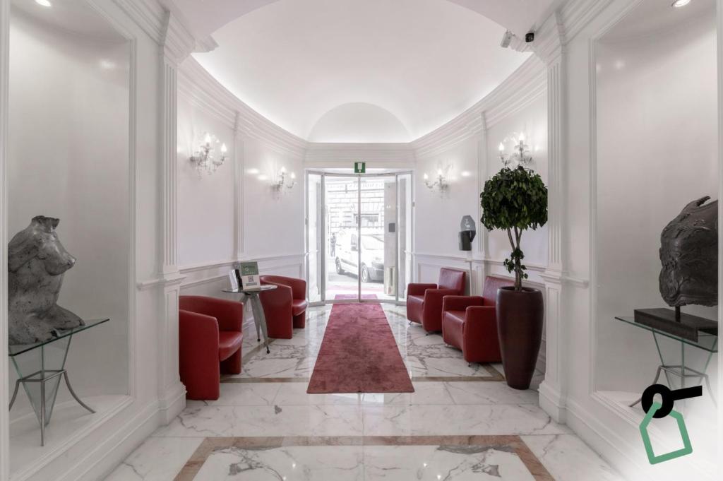 a lobby with red chairs and a red rug at HOTIDAY Hotel Roma Porta Pia in Rome