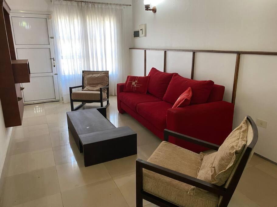 uma sala de estar com um sofá vermelho e cadeiras em Casa Pellegrini em Posadas