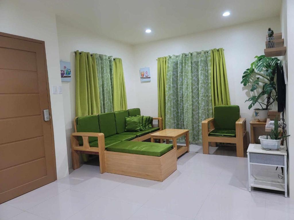 卡加延德奧羅的住宿－New Tropical Inspired Home，客厅配有绿色沙发和两把椅子
