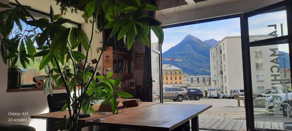 Una mesa en una habitación con vistas a la montaña en Cosy 4p Loft & CoWorking space 5m walk to ski lift en Briançon