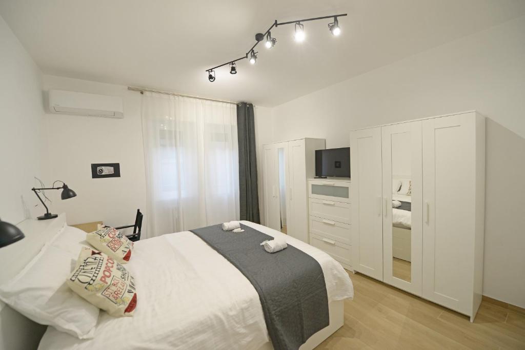 een witte slaapkamer met een bed en een kast bij Apartment Cinecittà in Rome