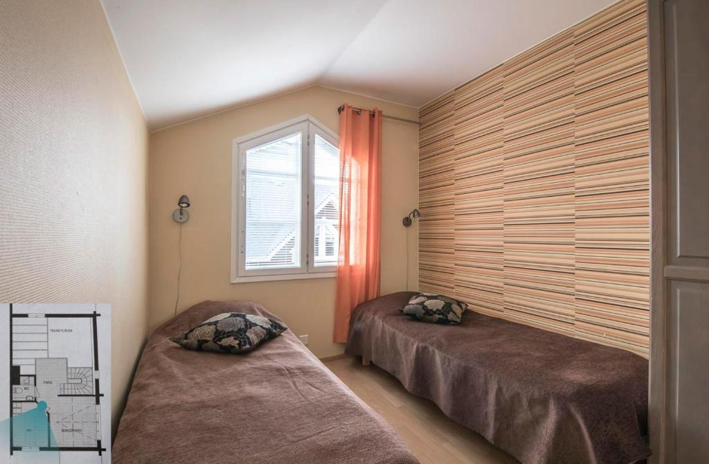 a bedroom with two beds and a window at Levillenet Glacier Alpine Chalets at Levi Centre in Levi