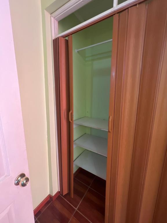 a closet with a glass door and shelves in it at Hotel Casa del profesor Iquique in Iquique