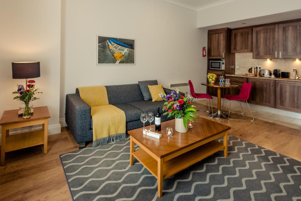 PREMIER SUITES Dublin, Leeson Street في دبلن: غرفة معيشة مع أريكة وطاولة