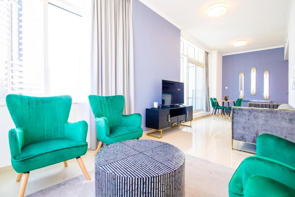 a living room with green chairs and a television at Modern Sea View 1Bedroom Dubai Marina in Dubai