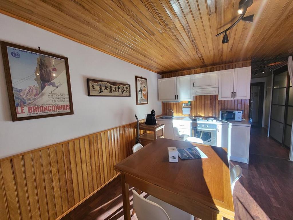 une cuisine avec une table et une salle à manger dans l'établissement Studio ensoleillé avec balcon, parking et casier à skis au centre de Montgenèvre - FR-1-266-186, à Montgenèvre