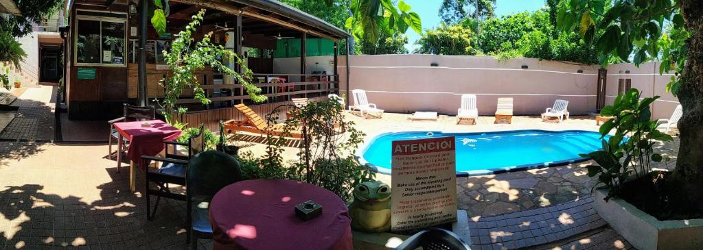 a swimming pool with a sign in front of it at Hostel & Posada Noelia in Puerto Iguazú
