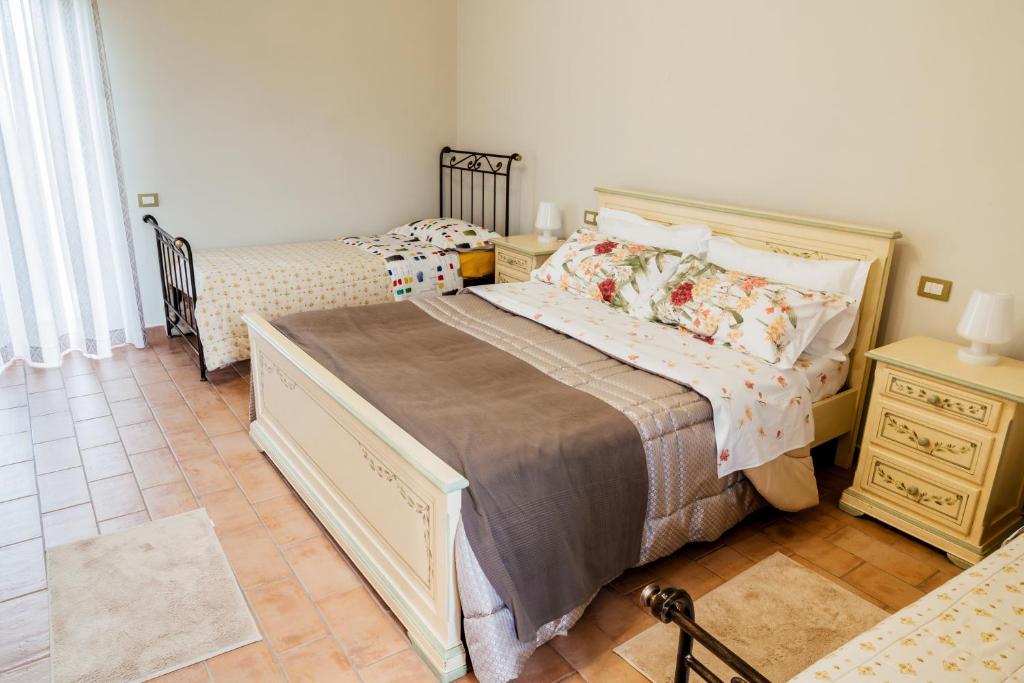 a bedroom with two twin beds and a night stand at Tenuta Tralice in Ruviano