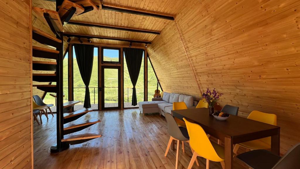 a dining room with a table and yellow chairs at Focus Point Drakhtik - Green Cabin in Drakhtik