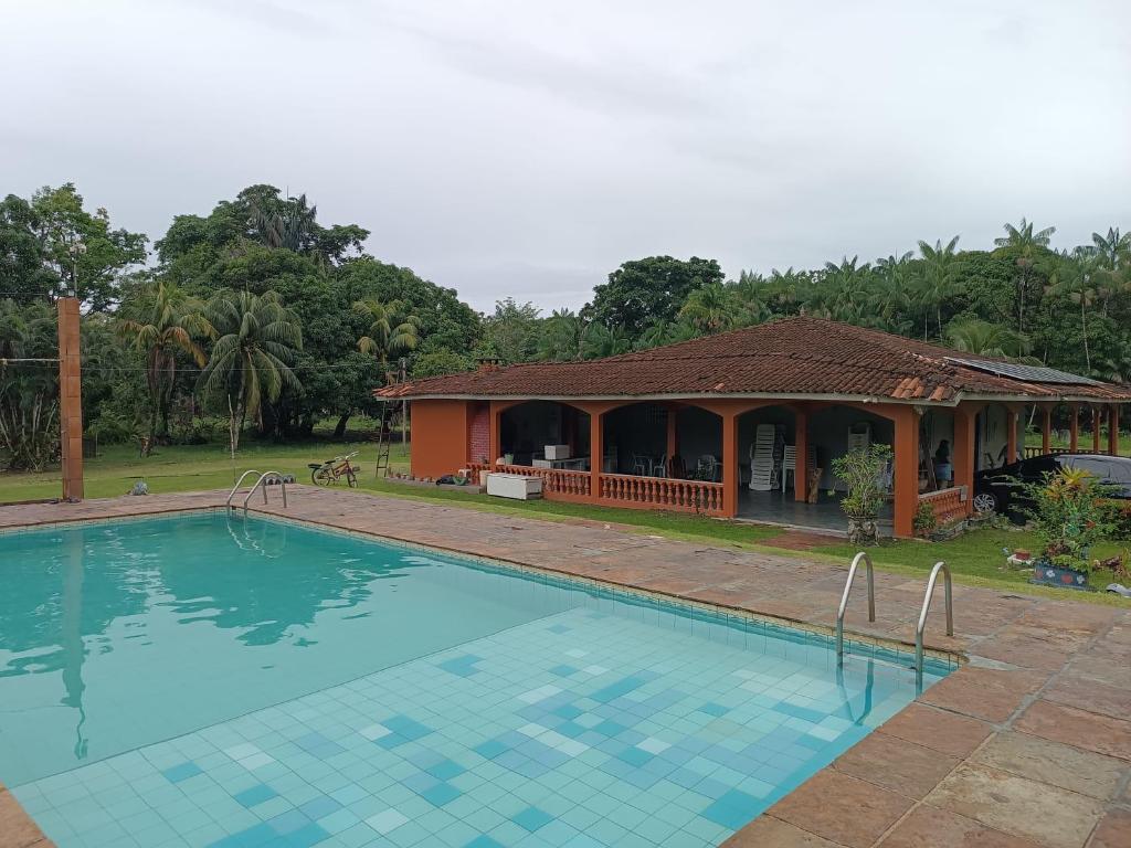 una casa con piscina di fronte a una casa di Chácara Calixto a Belém