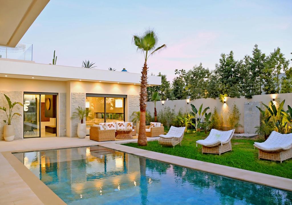 un patio trasero con piscina y una casa en Villa Amber, en Marrakech