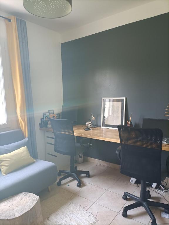 an office with a desk and two chairs and a table at Chambre calme dans une maison à la campagne in Vielmur