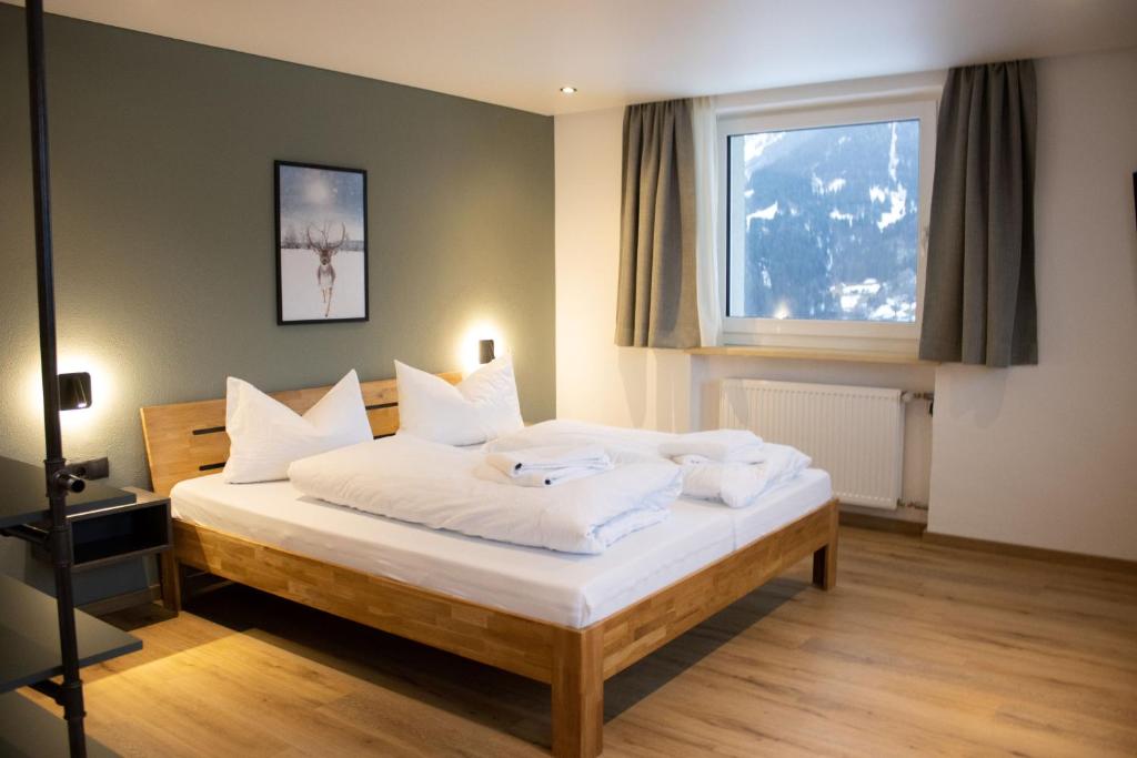 um quarto com uma cama com lençóis brancos e uma janela em Fairrooms - 24h Self-Check-In em Raggal
