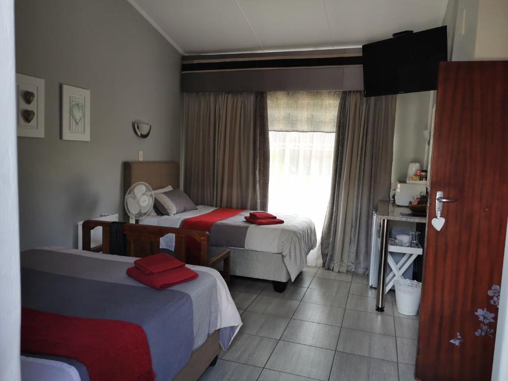 a hotel room with two beds and a window at Stew s Room in Polokwane