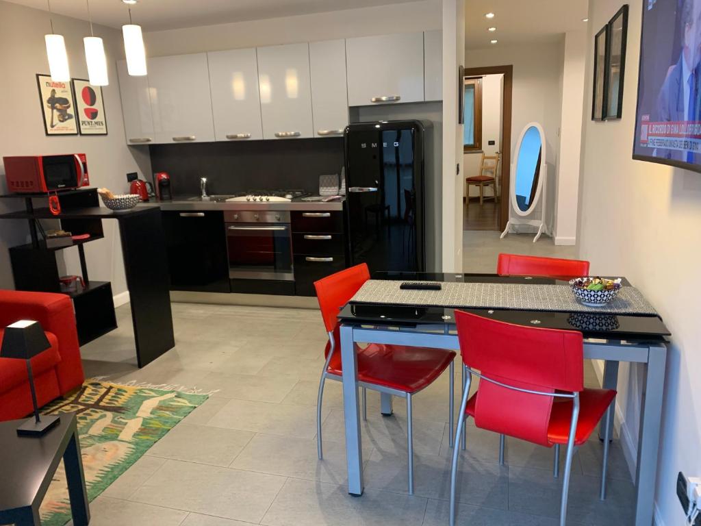 una cocina con sillas rojas y una isla de cocina en una habitación en CasaBella Inalpi Arena en Turín