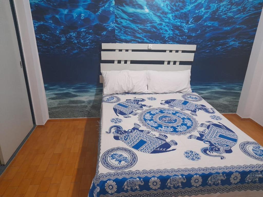a bed with a blue and white quilt on it at alquiler temporario en Córdoba Capital, excelente ubicación in Cordoba