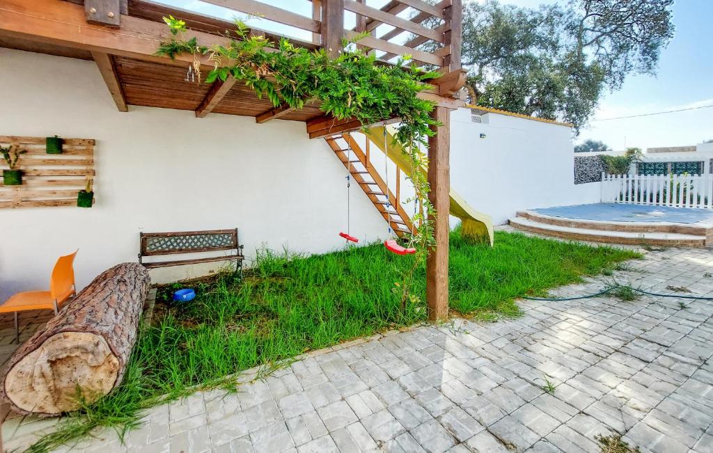 a garden with a wooden pergola and a bench at Nice Home In Barbate With Wi-fi in Barbate