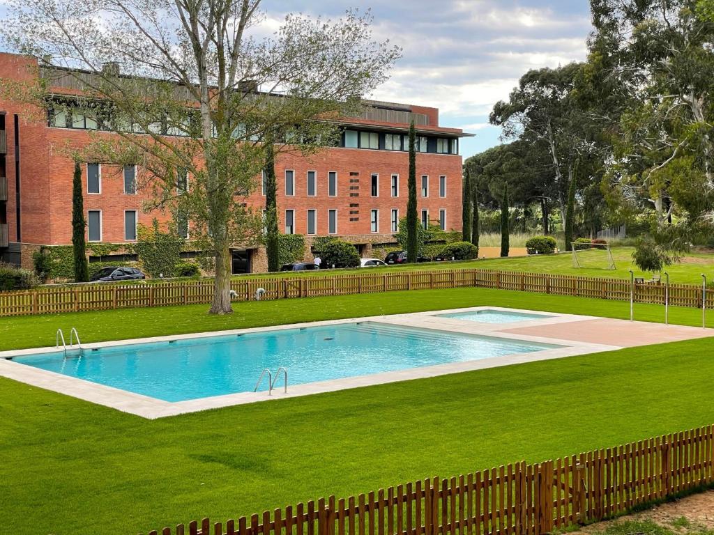 una piscina en un campo de césped con un edificio en Residencies del Golf 22 1-1, en Gualta