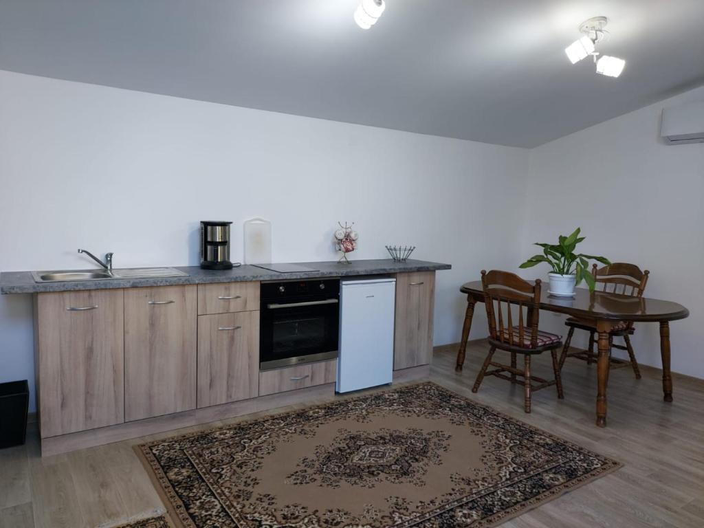 una cocina con armarios de madera y una mesa con sillas. en Lymore Guest house en Palamarza