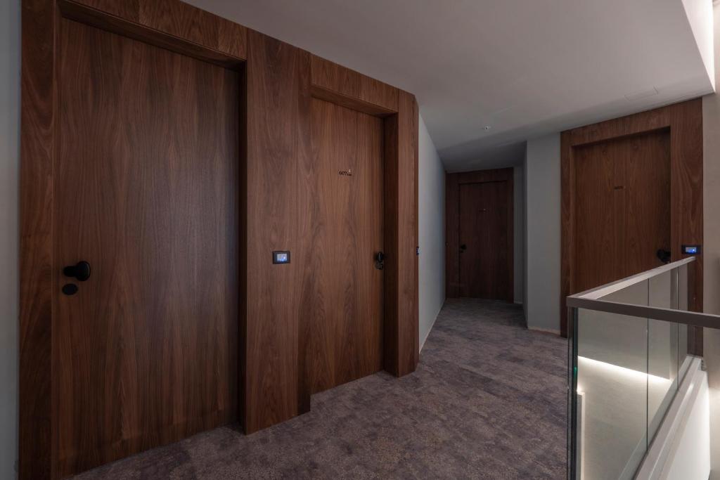 a hallway with two wooden doors and a staircase at Sea Star Budva in Budva