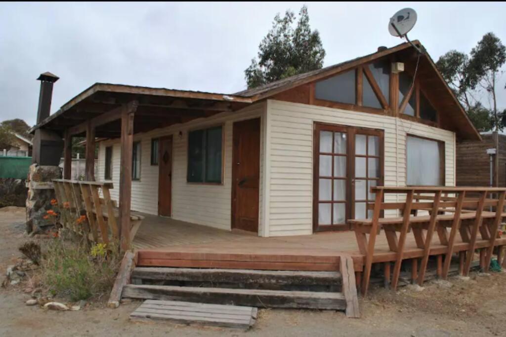 ein kleines Haus mit einer Veranda und einer Terrasse in der Unterkunft Casa Pichidangui, 8 personas. in Quilimarí