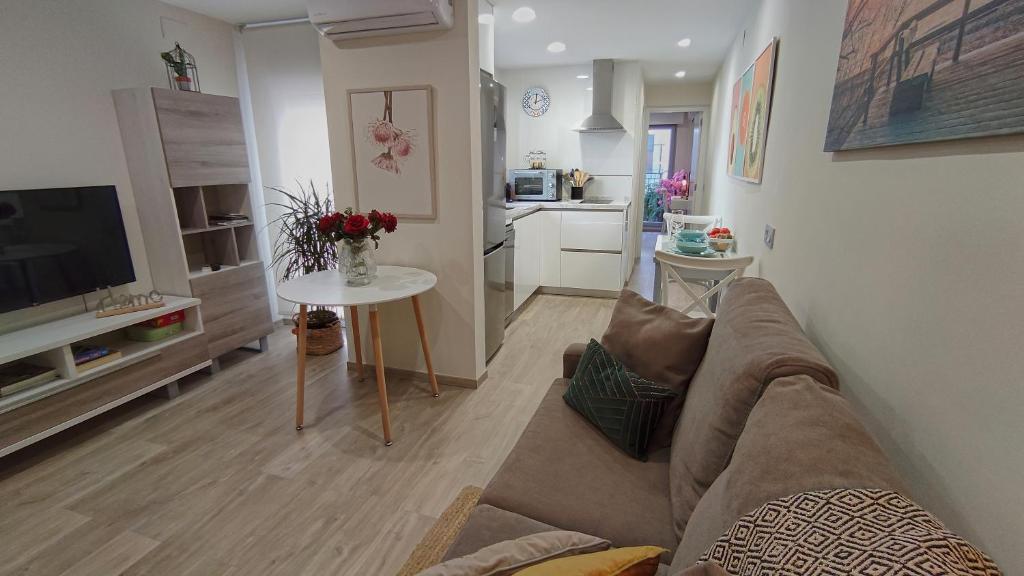 sala de estar con sofá, mesa y cocina en Apartamento la Unión II , calidad y comodidad, en Castellón de la Plana