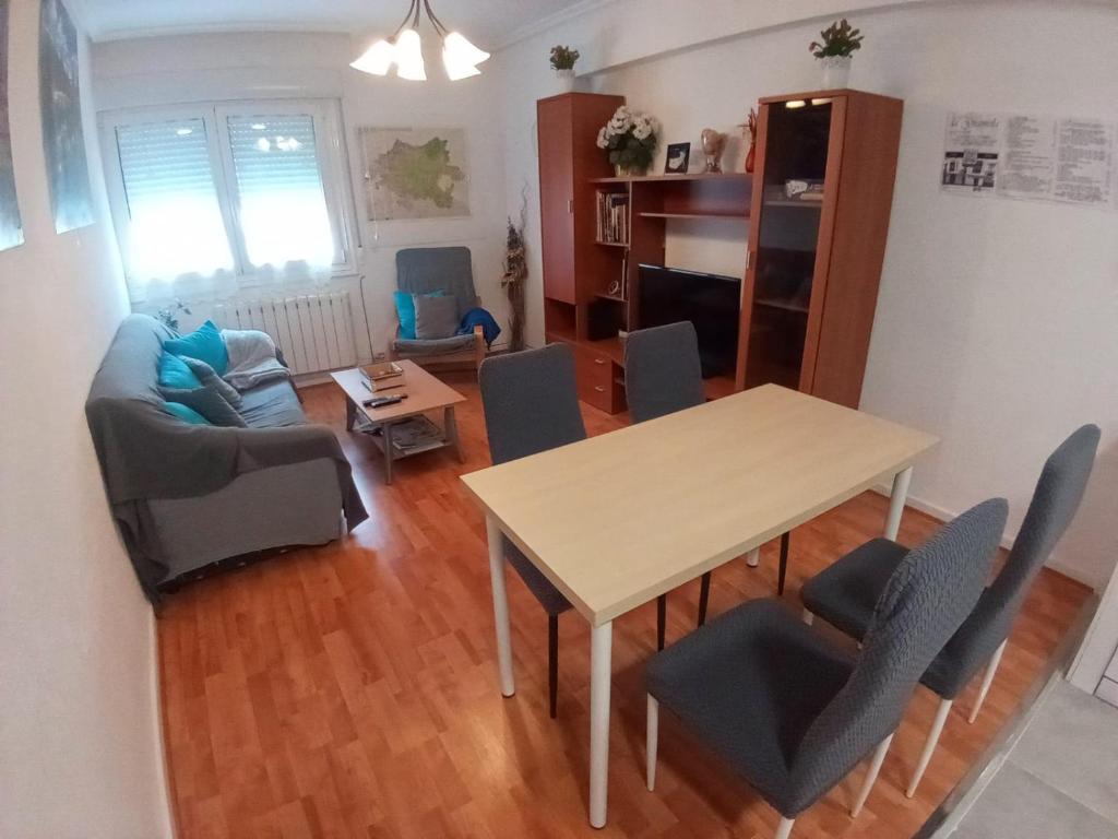 a dining room and living room with a table and chairs at MERINDADES AMAZUL MILANO - Piso turístico - Medina de Pomar in Medina de Pomar