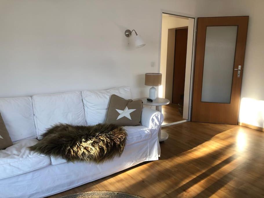 a living room with a white couch with a pillow at Alpsoul eine Ferienwohnung mit Charisma…. in Garmisch-Partenkirchen