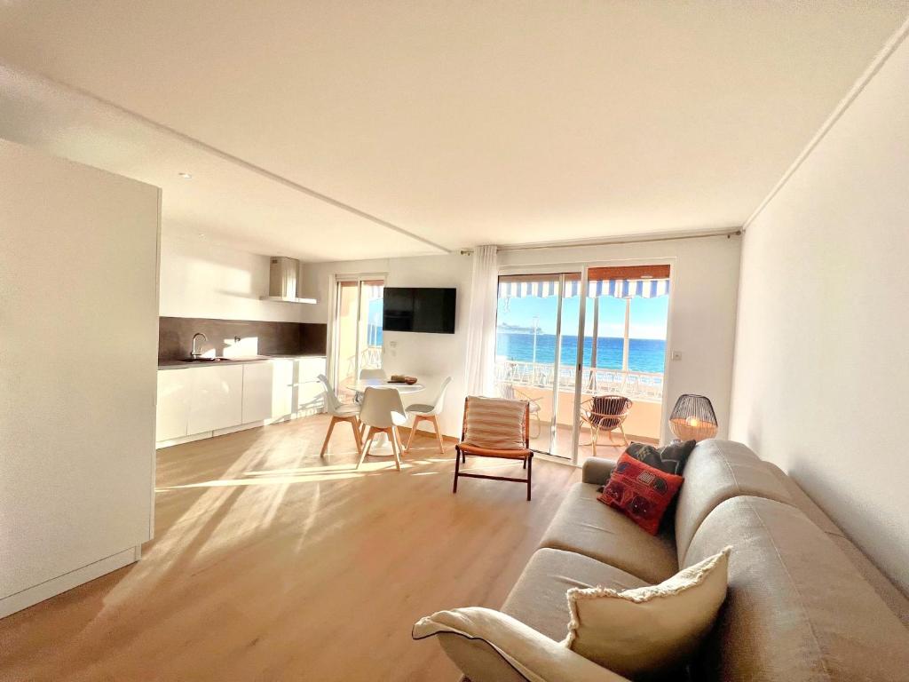 uma sala de estar com um sofá e uma mesa com cadeiras em Marjolaine luxury sea view, by Welcome to Cannes em Cannes