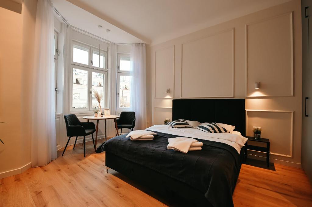 1 dormitorio con 1 cama y 1 mesa con sillas en Porta Apartments Novi Sad en Novi Sad