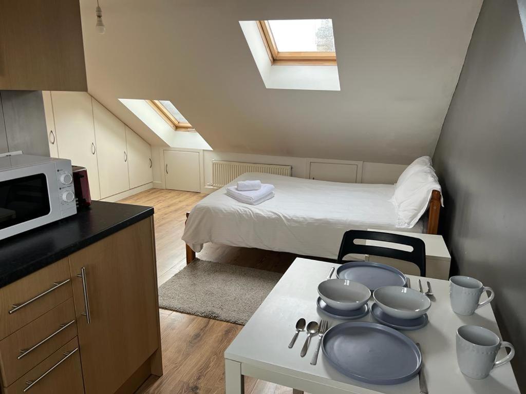 ein kleines Zimmer mit einem Bett und einem Tisch mit Töpfen und Pfannen in der Unterkunft Private Studio Room With Your Shower and Kitchen in London