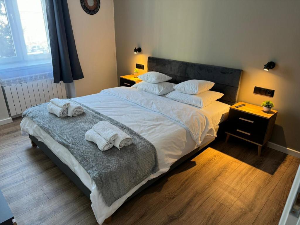 a bedroom with a large bed with towels on it at Lusia Apartment in Jarosław