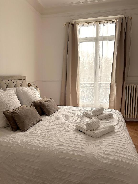 - un lit blanc avec des serviettes et une fenêtre dans l'établissement Le Pompon - Centre ville de Dijon, à Dijon