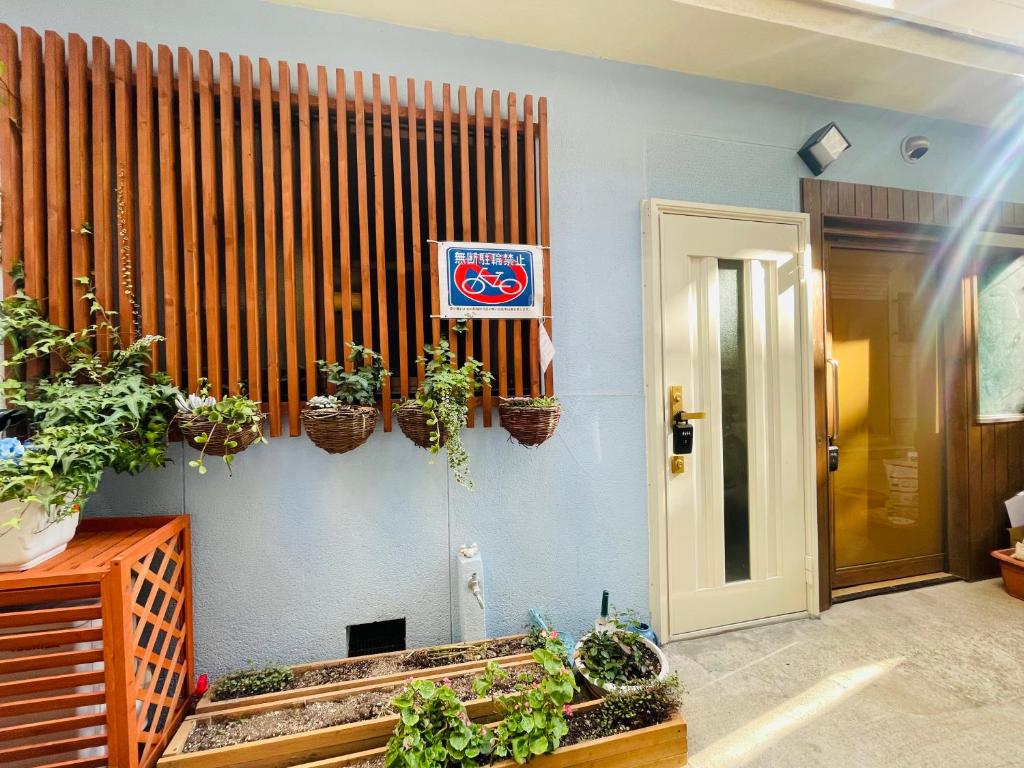 大阪的住宿－難波心斎橋10minutes民宿2号室，墙上有盆栽植物的房间