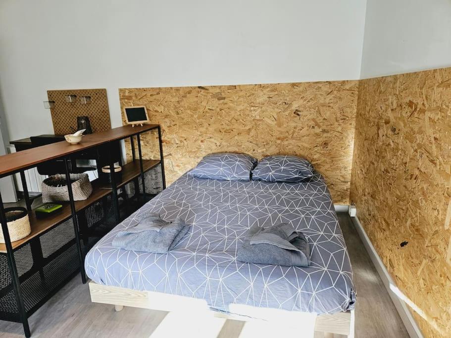 a bedroom with a bed with blue sheets and a desk at Le studio de Max - Terrasse et Parking in Valence