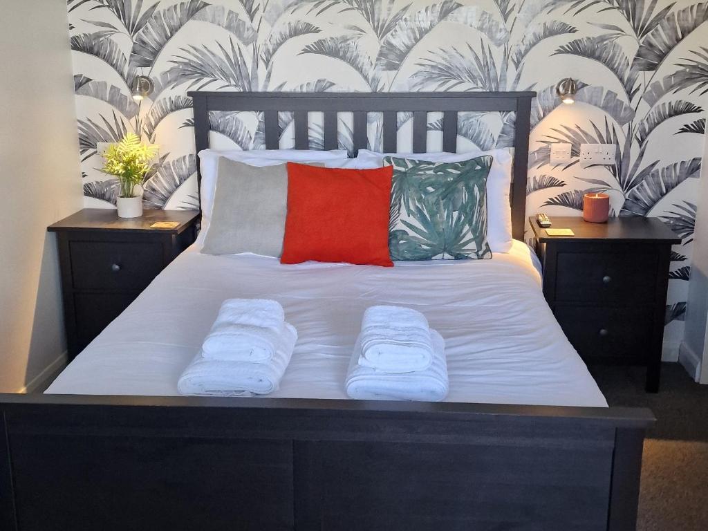 łóżko z 2 poduszkami i czerwoną poduszką w obiekcie Rutland Point Studio serviced accommodation Keystones Property Services w mieście Morcott