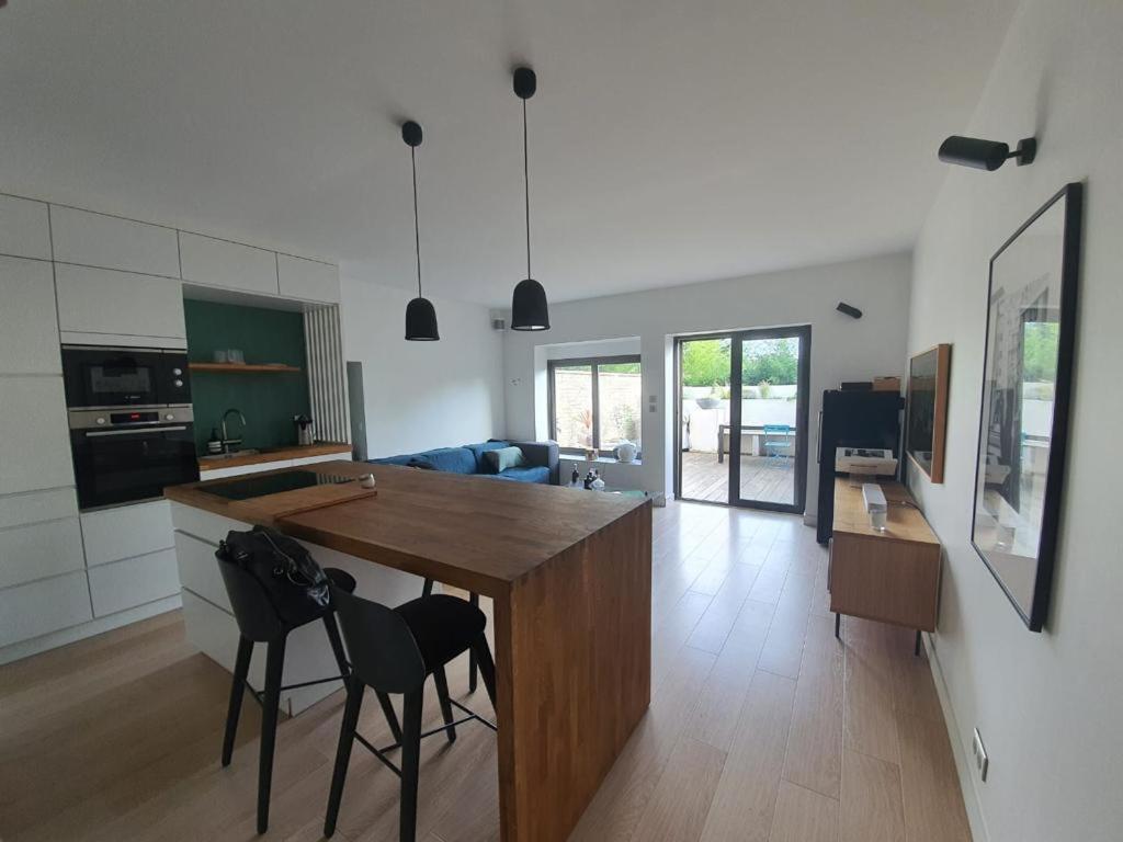 a kitchen and living room with a table and chairs at Charmant appartement Saint Cyr au mont d’or in Saint-Romain-au-Mont-dʼOr