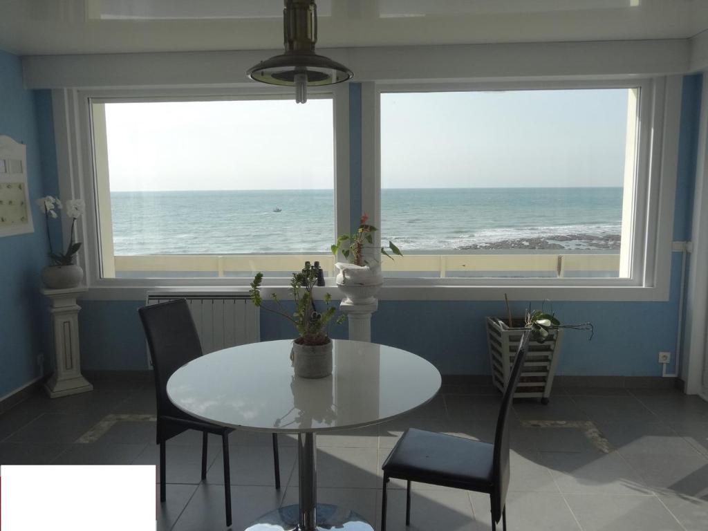 - une salle à manger avec une table et une vue sur l'océan dans l'établissement Villa Face Mer, à Audresselles
