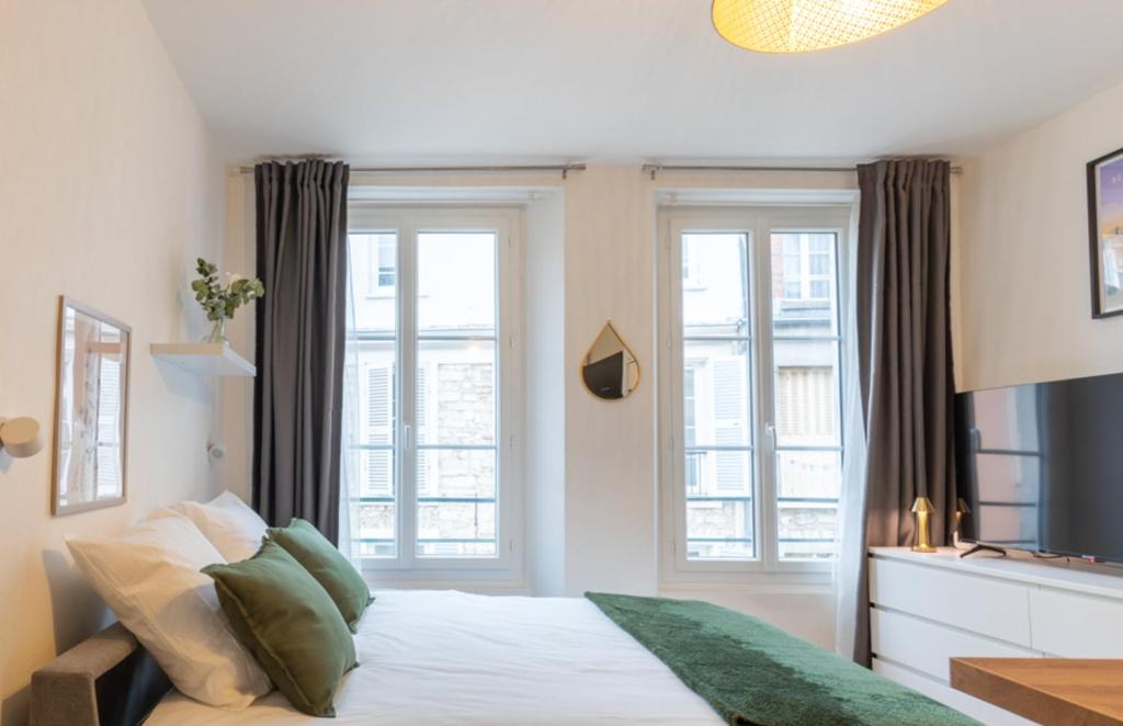 - une chambre avec un lit et 2 fenêtres dans l'établissement Cœur de Fontainebleau: Confort, Calme & Haut débit, à Fontainebleau