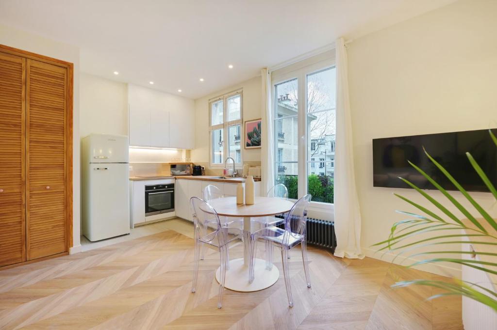 a kitchen with a table and chairs in a kitchen at Comfy Suite by Les Maisons de Charloc Homes in Boulogne-Billancourt
