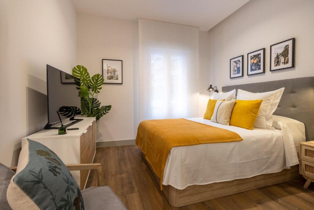 a bedroom with a large bed with yellow pillows at Bonito Loft en Barrio de Chamberi Quevedo I in Madrid