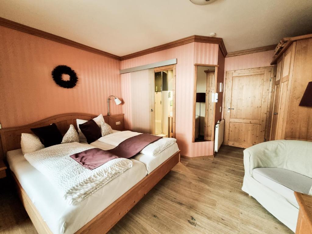 Cama grande en habitación con paredes rosas en Landhaus Talblick- Boutique B&B-Pension-Gästehaus en Brotterode