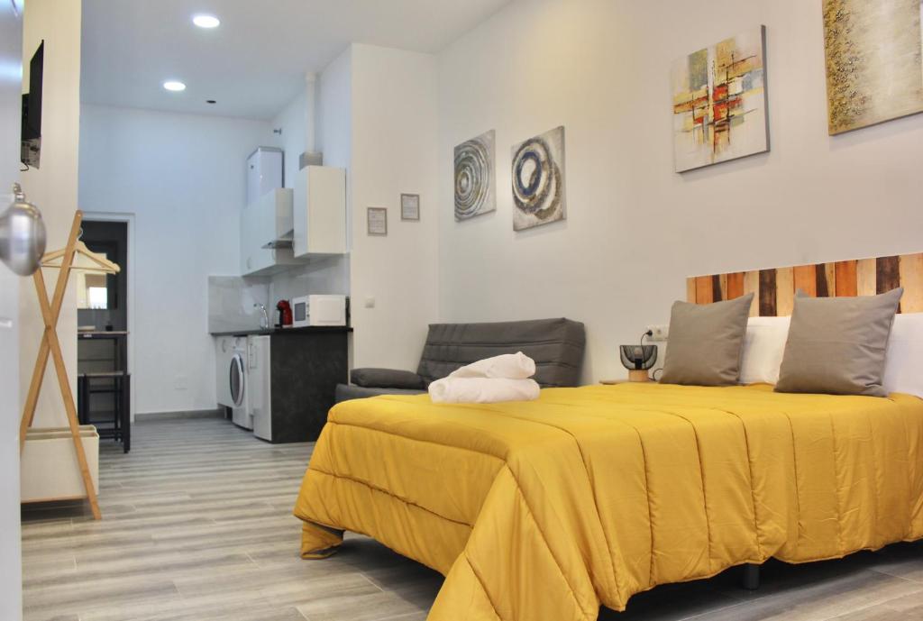 1 dormitorio con cama amarilla y sala de estar en NUEVO ESTUDIO DIVINA PASTORA N-1, en Málaga