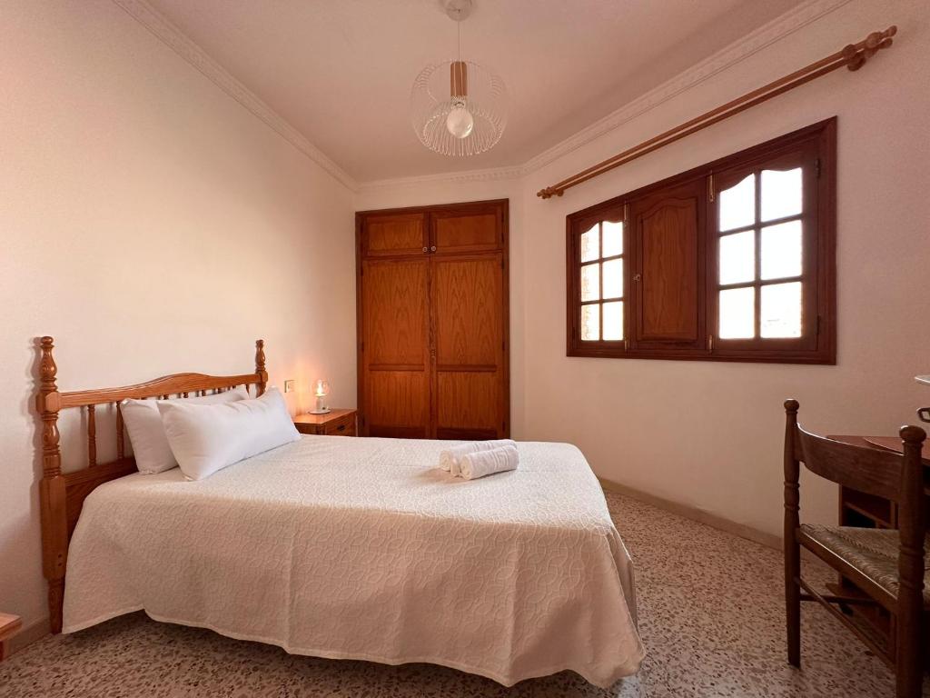 una camera da letto con un letto con copriletto bianco e una finestra di Ten minutes from airport a Vecindario